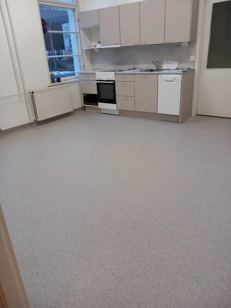 Image of a modern kitchen interior with grey cabinets, appliances, and a tiled floor.